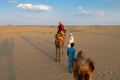 Female tourist riding camel, Camelus dromedarius, at sand dunes of Thar desert, Rajasthan, India. Camel riding is a favourite Royalty Free Stock Photo