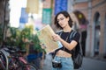 Tourist searching for city destination on map outdoors.  Woman standing on street with map in hands Royalty Free Stock Photo