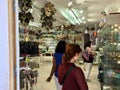 A female tourist shopping for glass sculptures at a shop in Murano, Italy. Murano is famous for its Venetian glass