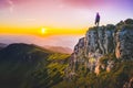 Female tourist silhouette on the top of the carpathian mountains looking at beautiful colorful summer sunset. Meadow full of lila Royalty Free Stock Photo