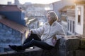 A female tourist sits on a masonry wall in an old European city. Royalty Free Stock Photo