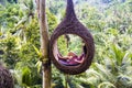 A female tourist is sitting on a large bird nest on a tree at Bali island Royalty Free Stock Photo