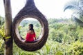 A female tourist is sitting on a large bird nest on a tree at Bali island Royalty Free Stock Photo