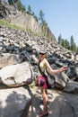 A female tourist starts the climb up to Devil`s Postpile National Monument, carrying her camera and camera bag on a hot summer da
