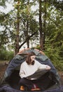 A female tourist studies the march on a map while sitting in a tent in the woods Royalty Free Stock Photo