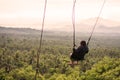 A female tourist swings enjoying the scenic landscape in a rural park in Liliw Laguna