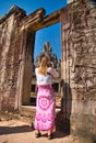 A female tourist takes a picture of temple ruins at the ancient Khmer site of Angkor Thom near Siem Reap in Cambodia