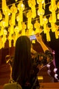 Female tourist taking picture of Thai traditional lanterns with mobile smart phone