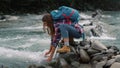 Tourist touching water in river. Tired woman drinking fresh water from stream Royalty Free Stock Photo