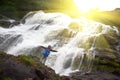 Female tourist under water Falls in mountains of Norway