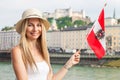 Female tourist on vacation in Salzburg Austria holding the Austrian flag