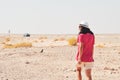 Female tourist walk on deserted landscape Jordan countryside solo with car in background. Road trip in Jordan, middle east explore Royalty Free Stock Photo