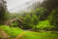 Female tourist walk on old ottoman empire bridge in Ayder , Turkey. Firtina Creek travel points of interest Royalty Free Stock Photo