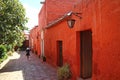 Female tourist walking along deep orange colored historic buildings in Santa Catalina Monastery, Arequipa, Peru Royalty Free Stock Photo