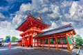 Female tourists hold an umbrella during heavy rain at the entrance to the shrine in Kyoto, Japan