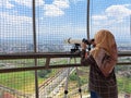 Female tourists see the view of Purwokerto City using telescope at the Lotus View Tower Royalty Free Stock Photo