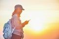 Female tourists viewing the map on the phone with sunset background.