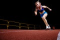 Female track runner bursting off starting block