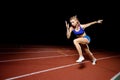 Female track runner bursting off starting block Royalty Free Stock Photo