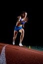 Female track runner bursting off starting block Royalty Free Stock Photo