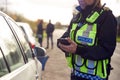 Female Traffic Police Officer Recording Details Of Road Traffic Accident On Mobile Phone Royalty Free Stock Photo