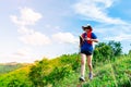 A female trail runner, dressed for runners, sportswear, is practicing on a dirt path in a high mountain forest. with a happy mood