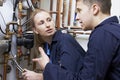 Female Trainee Plumber Working On Central Heating Boiler Royalty Free Stock Photo