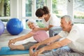 Female trainer assisting senior couple in performing exercise Royalty Free Stock Photo