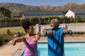 Female trainer assisting senior man in performing exercise Royalty Free Stock Photo