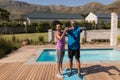 Female trainer assisting senior man in performing exercise Royalty Free Stock Photo