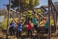 Female trainer instructing women to climb a rope in the boot camp