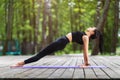 Female trainer in sportswear, practicing yoga asanas, doing the reverse plank Royalty Free Stock Photo