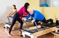 Female trainer working with senior man at rehab. Female trainer helping senior man at sport gym Royalty Free Stock Photo