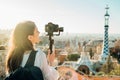 Female travel photographer/videographer and bloger using camera with gimbal stabiliser crane in Barcelona,Spain.Travel photography