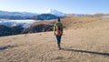 A female traveler with a backpack admires the view of a beautiful landscape. Elbrus mountains, fields, autumn nature.