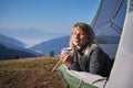 Charming young woman hiker resting in camp tent in mountains. Royalty Free Stock Photo