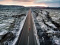 Female traveler on Icelandic road surrounded by lava plains