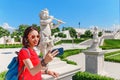 Female traveler making selfie with smart phone with Cupid statue in summer garden or park Royalty Free Stock Photo