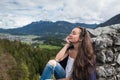 Female traveler sits on peak of mountain