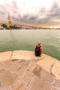 Female traveler sitting on a background of Venice landmark, Italy. Royalty Free Stock Photo
