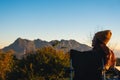 A woman sitting on folding chair, watching mountain view and and sunrise in the morning