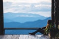 A female sitting and looking at a beautiful mountain and nature view before sunset Royalty Free Stock Photo