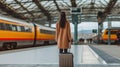 A Female traveler in stylish outfit standing with suitcase on platform of railway station. Generative AI