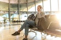 Female traveler talking on her cell phone while waiting to board a plane at departure gates at airport terminal. Royalty Free Stock Photo