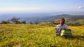 Female traveller with backpack making photo of mountain lanscape under blue sky Royalty Free Stock Photo