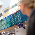 Female traveller checking flight departures board. Royalty Free Stock Photo