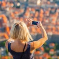 Female traveller make a photo of Dubrovnik to the phone.