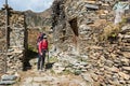 Female trekker passing traditional village.