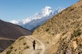 Female trekker walking alone though mountain desert. Royalty Free Stock Photo