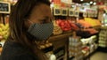 Female with trolley in grocery store with mask